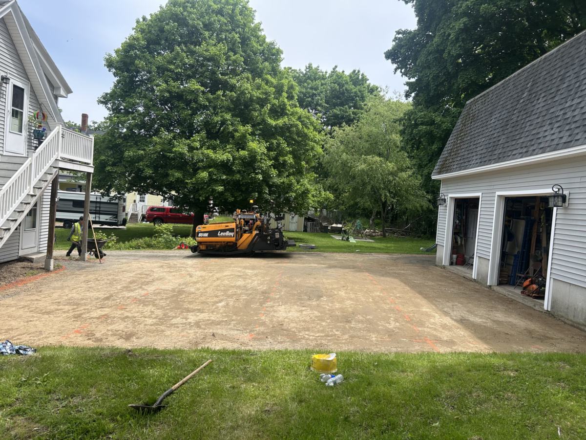 Zilembo's paving crew and asphalt paver on a graded driveway base in Portland, Maine